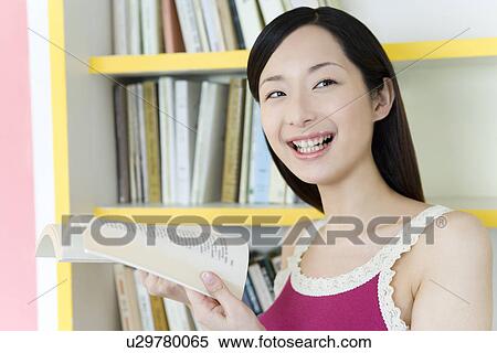 Portrait of a Young Woman Reading a Book, Smiling, Front View View Large Photo Image Stock Photography - Portrait of a Young Woman Reading a Book, Smiling, Front View. Fotosearch