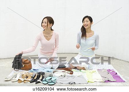 Picture - Two women smiling and selling their stuff at a flea market, front view, white background. Fotosearch