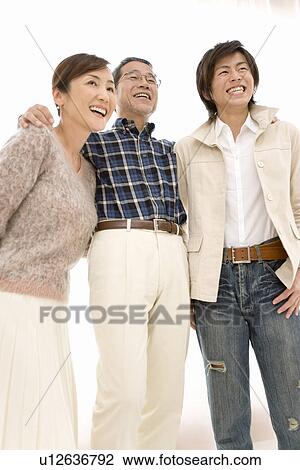 A Family Smiling and Looking Away Together, Low Angle View View Large Photo Image Stock Image - A Family Smiling and Looking Away Together, Low Angle View. Fotosearch