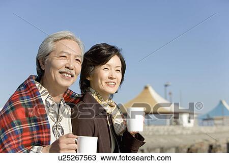 A Mature Couple Holding a Cup and Looking Away, Head and Shoulder View Large Photo Image Stock Image - A Mature Couple Holding a Cup and Looking Away, Head and Shoulder. Fotosearch
