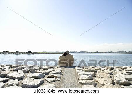 A Mature Couple Nestling Close to Each Other on the Seashore, Rear View, Waist Up, Copy Space View Large Photo Image Stock Photography - A Mature Couple Nestling Close to Each Other on the Seashore, Rear View, Waist Up, Copy Space. Fotosearch