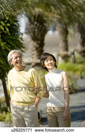 A Mature Couple Walking Arm in Arm, Front View, Three Quarter Length View Large Photo Image Stock Image - A Mature Couple Walking Arm in Arm, Front View, Three Quarter Length. Fotosearch