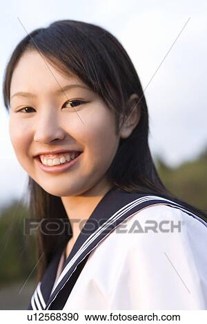 Portrait of a teenage girl standing in schoolyard, smiling and looking at camera View Large Photo Image Stock Image - Portrait of a teenage girl standing in schoolyard, smiling and looking at camera. Fotosearch