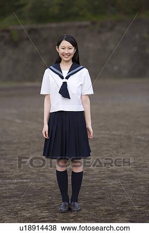 Stock Photo - Portrait of a teenage girl standing in schoolyard, smiling and looking at camera. Fotosearch