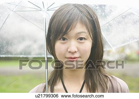 Portrait of a woman holding an umbrella, smiling and looking at camera, front view, Japan View Large Photo Image Stock Photograph - Portrait of a woman holding an umbrella, smiling and looking at camera, front view, Japan. Fotosearch