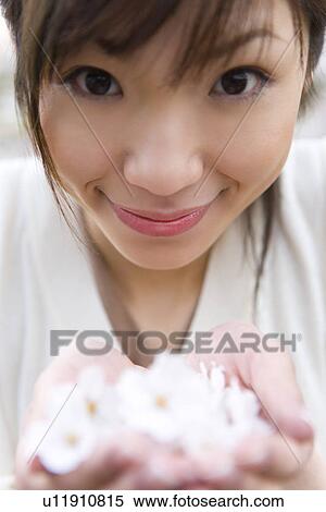 Portrait of a woman scooping up cherry flowers with hands, smiling and looking at camera, front view, close up, differential focus, Japan View Large Photo Image Stock Photography - Portrait of a woman scooping up cherry flowers with hands, smiling and looking at camera, front view, close up, differential focus, Japan. Fotosearch