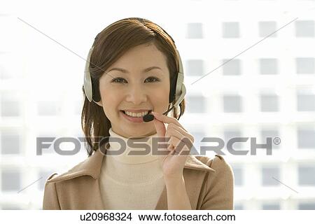 Portrait of a woman wearing a hands-free headset, looking at camera, front view, differential focus View Large Photo Image Picture - Portrait of a woman wearing a hands-free headset, looking at camera, front view, differential focus. Fotosearch