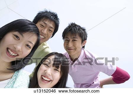 Portrait of four young people under the blue sky, smiling and looking at camera, low angle view, blue background, Japan View Large Photo Image Stock Photograph - Portrait of four young people under the blue sky, smiling and looking at camera, low angle view, blue background, Japan. Fotosearch