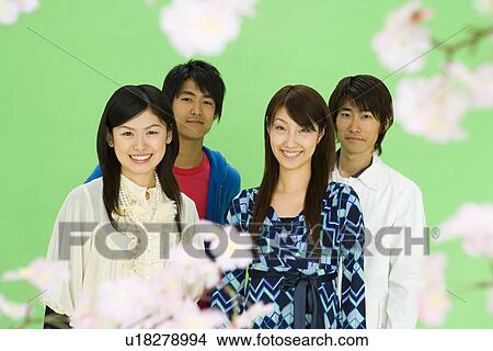 Portrait of four young people with cherry flowers, smiling and looking at camera, front view, green background View Large Photo Image Picture - Portrait of four young people with cherry flowers, smiling and looking at camera, front view, green background. Fotosearch