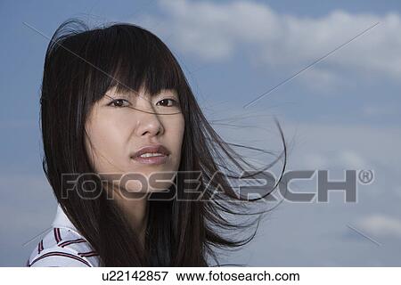 Stock Photo - Young woman, smiling, front view, close up. Fotosearch