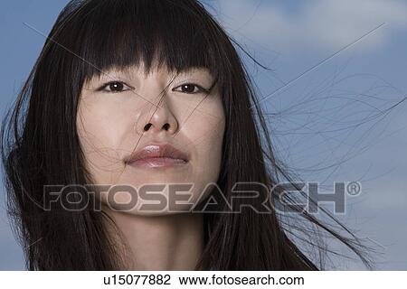 Stock Image - Young woman, smiling, front view. Fotosearch