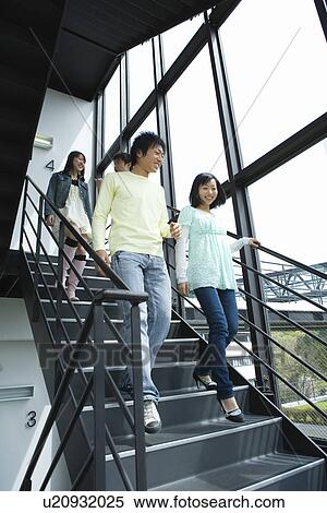 Four young people walking down the stairs, low angle view View Large Photo Image Stock Photography - Four young people walking down the stairs, low angle view. Fotosearch