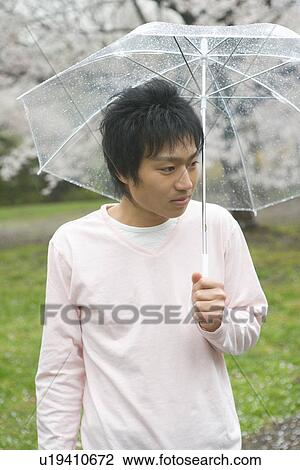 Portrait of a man holding an umbrella, front view, Japan View Large Photo Image Stock Image - Portrait of a man holding an umbrella, front view, Japan. Fotosearch