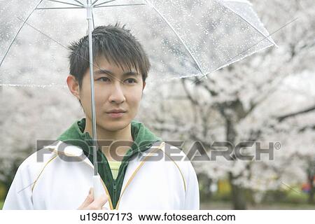 Portrait of a man holding an umbrella, front view, Japan View Large Photo Image Stock Image - Portrait of a man holding an umbrella, front view, Japan. Fotosearch