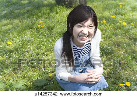 Portrait of a woman crouching down and looking at camera on field, high angle view, Japan View Large Photo Image Stock Image - Portrait of a woman crouching down and looking at camera on field, high angle view, Japan. Fotosearch
