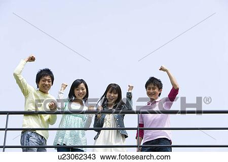 Portrait of four young people punching air behind the railing, low angle view, blue background, copy space, Japan View Large Photo Image Stock Image - Portrait of four young people punching air behind the railing, low angle view, blue background, copy space, Japan. Fotosearch