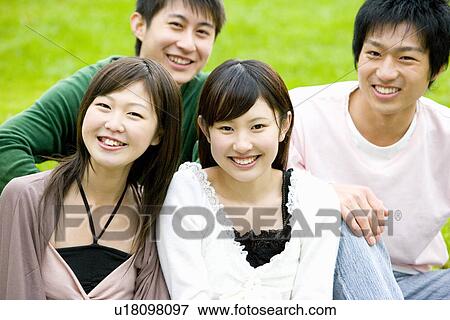 Portrait of four young people sitting on lawn, smiling and looking at camera, front view, Japan View Large Photo Image Stock Photo - Portrait of four young people sitting on lawn, smiling and looking at camera, front view, Japan. Fotosearch