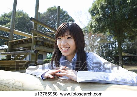 Woman smiling and leaning on a log, front view, Japan View Large Photo Image Stock Photo - Woman smiling and leaning on a log, front view, Japan. Fotosearch
