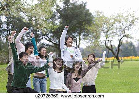 Stock Photo - Young Men and Women Holding Fists in the Air, Side View. Fotosearch