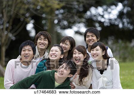 Stock Image - Young Men and Women Looking Up and Laughing, Front Focus, . Fotosearch