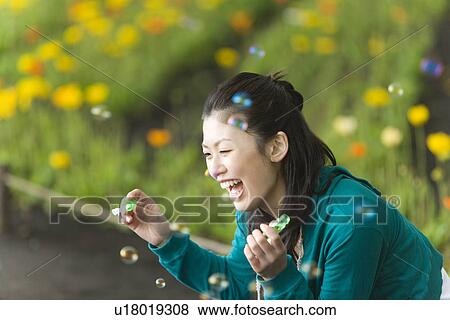 Young Woman Blowing Soap Bubbles, Differential Focus, View Large Photo Image Stock Photo - Young Woman Blowing Soap Bubbles, Differential Focus, . Fotosearch