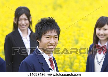 Stock Photograph - Businesswoman and Students Standing in Rape Field, Side View, Head and Shoulder, Differential Focus. Fotosearch