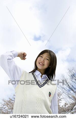Stock Image - High School Girl In Front Of Cherry Blossoms. Fotosearch
