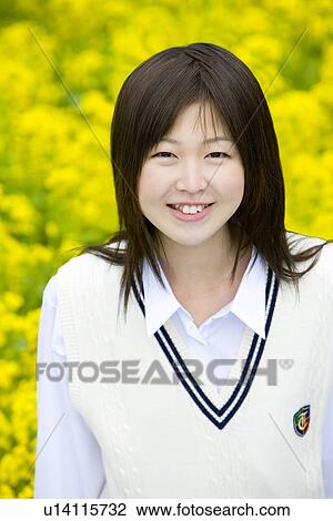 Stock Image - High School Girl In Rape Seed Blossom Field, Differential Focus. Fotosearch