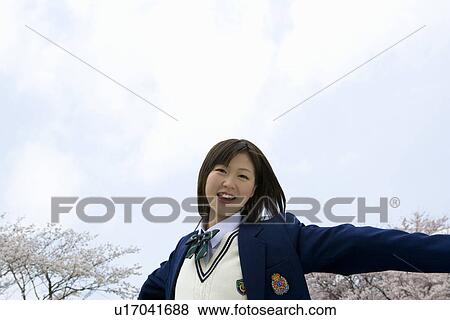 High School Girl Spreading Arms, Cherry Blossoms in the Background View Large Photo Image Stock Photo - High School Girl Spreading Arms, Cherry Blossoms in the Background. Fotosearch