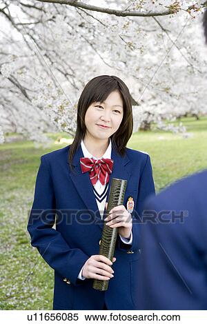 Stock Photography - High School Students Under Cherry Blossoms with Holding Diploma. Fotosearch