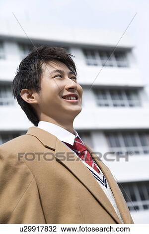 Stock Image - Portrait of a teenage boy smiling in campus. Fotosearch