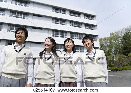 Stock Photo - Portrait of four high school students smiling and standing side by side in campus. Fotosearch