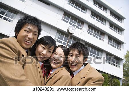 Stock Photography - Portrait of four high school students embracing each other, smiling and looking at camera. Fotosearch