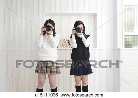 Portrait of twin sisters holding cameras and photographing, front view View Large Photo Image Stock Photograph - Portrait of twin sisters holding cameras and photographing, front view. Fotosearch