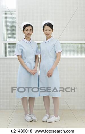 Portrait of two nurses, twin sisters, smiling and looking at camera, front view View Large Photo Image Stock Photo - Portrait of two nurses, twin sisters, smiling and looking at camera, front view. Fotosearch