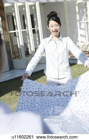 Twin sisters holding a sheet on garden, smiling, front view, rear view View Large Photo Image Stock Image - Twin sisters holding a sheet on garden, smiling, front view, rear view. Fotosearch