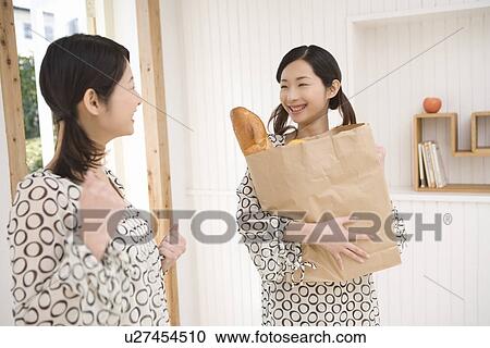 Twin sisters smiling, one holding a shopping bag, front view, side view View Large Photo Image Stock Image - Twin sisters smiling, one holding a shopping bag, front view, side view. Fotosearch