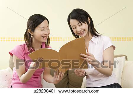 Two Young Twin Sisters Reading a Book, Smiling, Front View View Large Photo Image Stock Image - Two Young Twin Sisters Reading a Book, Smiling, Front View. Fotosearch