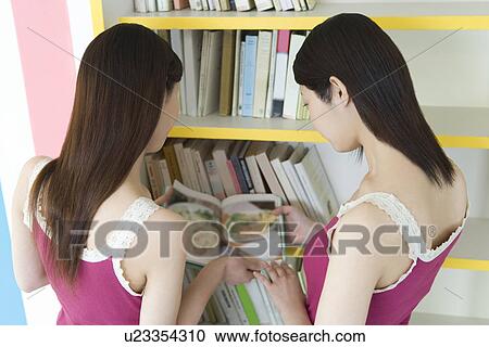 Two Young Twin Sisters Reading a Recipe Book, Rear View View Large Photo Image Stock Image - Two Young Twin Sisters Reading a Recipe Book, Rear View. Fotosearch