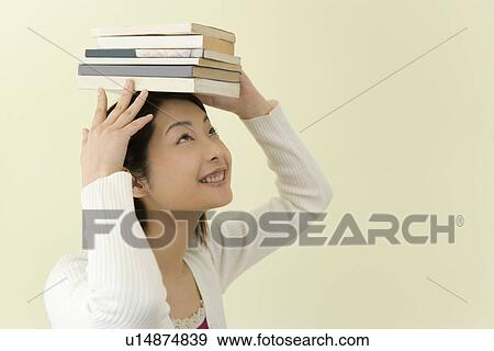 Young Woman Balancing Books on Her Head, Smiling, Side View View Large Photo Image Stock Photo - Young Woman Balancing Books on Her Head, Smiling, Side View. Fotosearch