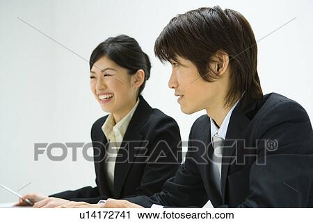 Stock Image - Businessman and Businesswoman In Meeting, Side View. Fotosearch