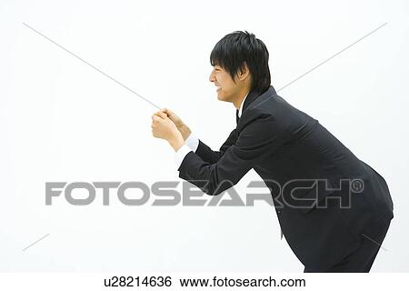 Stock Photograph - Businessman Bending Forward, Side View, Three Quarter Length, Copy Space. Fotosearch
