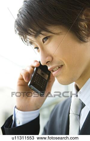 Stock Image - Businessman Talking on Mobile Phone, Side View, Close Up . Fotosearch
