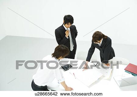 Stock Image - Businessmen and Businesswoman In Meeting, High Angle View. Fotosearch