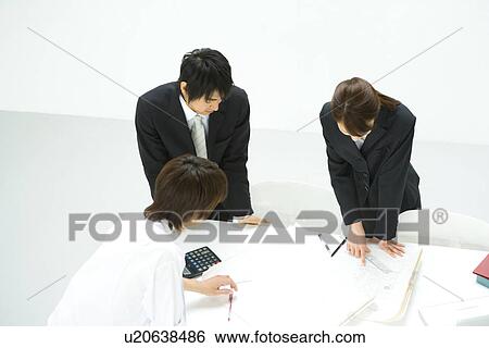 Stock Photograph - Businessmen and Businesswoman In Meeting, High Angle View. Fotosearch