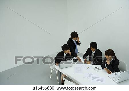 Stock Image - Businessmen and Businesswomen In Meeting, High Angle View. Fotosearch