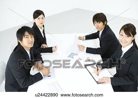 Stock Image - Businessmen And Businesswomen In Meeting, Waist Up, Side View, High Angle View. Fotosearch