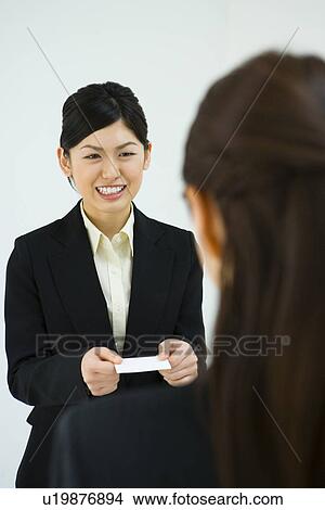 Picture - Businesswoman Exchanging Business Cards, Smiling, Three Quarter Length, Front View, Rear View. Fotosearch