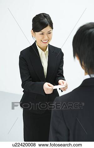 Stock Photo - Exchanging Business Cards, Smiling, Three Quarter Length, Front View, Rear View, High Angle View. Fotosearch