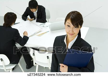 Picture - Portrait of a Businesswoman and Businessmen talking in the Background, High Angle View. Fotosearch